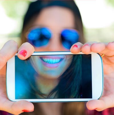 Mujer sonriendo con gafas de sol y corazón dibujado