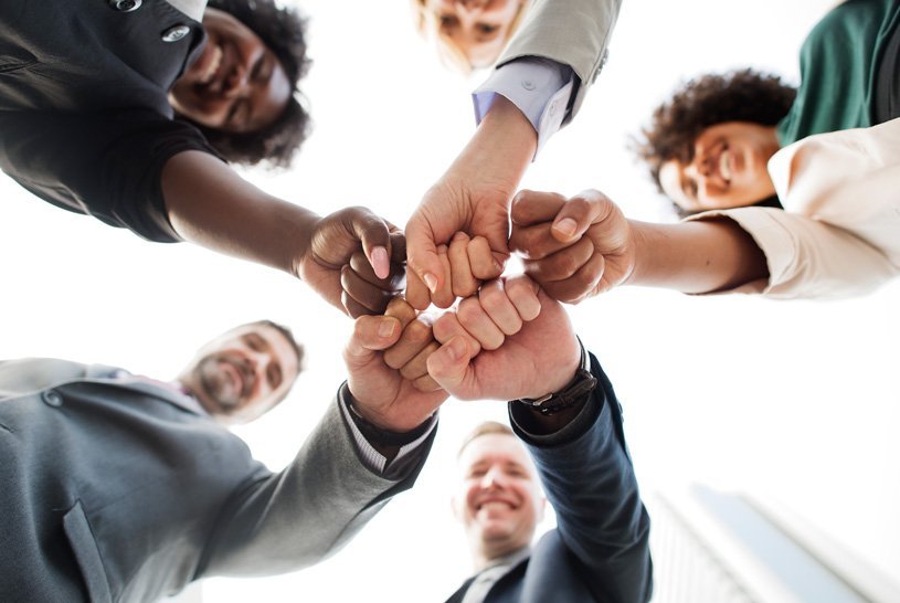 Manos de personas unidas en círculo como símbolo de equipo